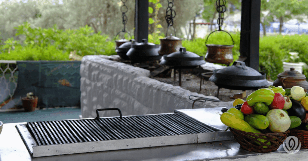 Stainless steel outdoor BBQ island with built-in grill, counter, and sink