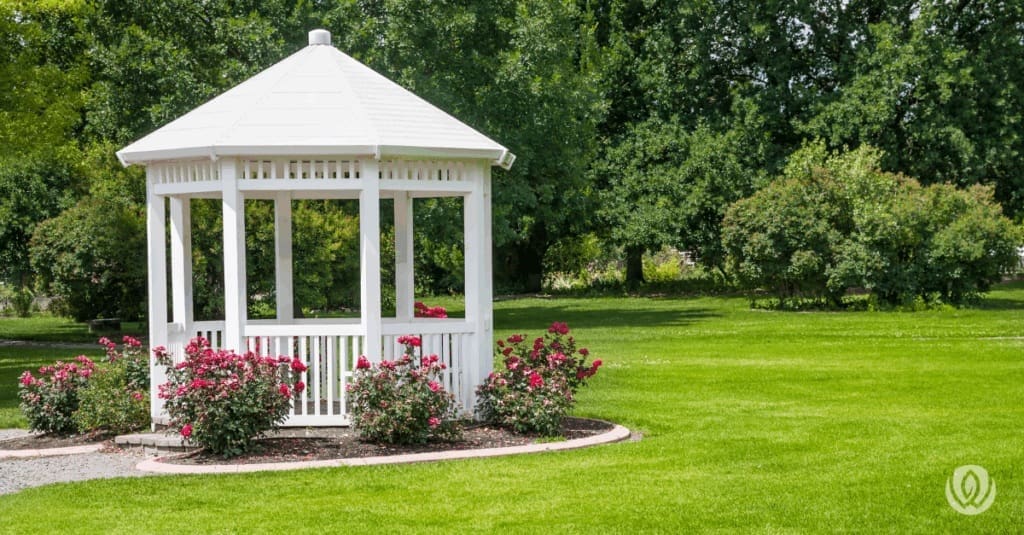 Classic round gazebo with roof in landscaped yard